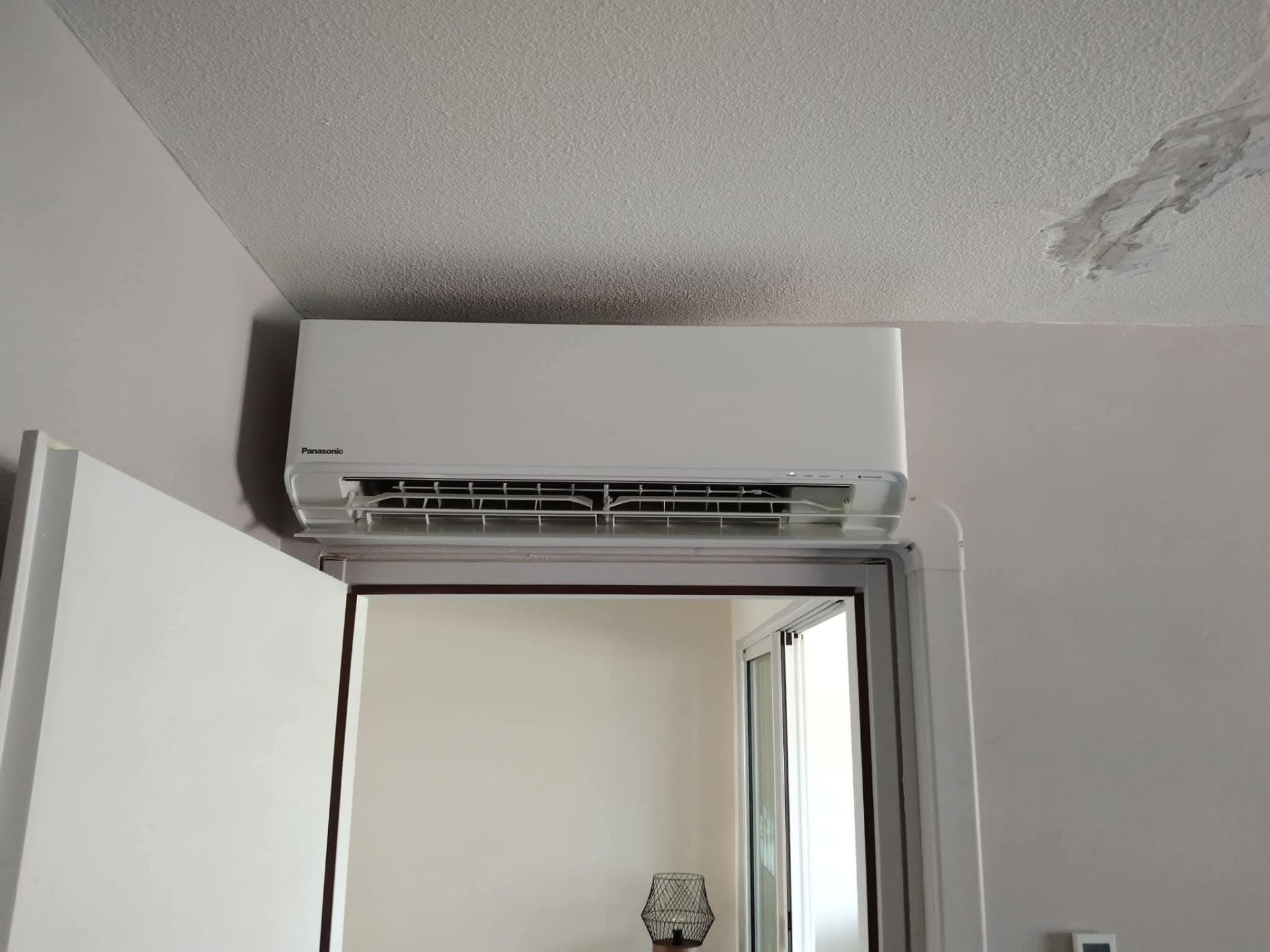 Remplacement 9K BTU Panasonic – Rivière Salée – climatisation Martinique Climatiseur mural Panasonic 9 000 BTU installé au-dessus d'une porte intérieure à Rivière-Salée, emplacement choisi pour bien répartir l'air dans la pièce – Rivière Salée, Martinique – LD CLIM 972