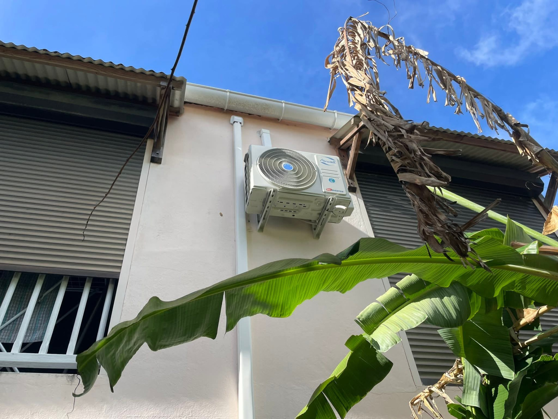 Remplacement 9k BTU – Le Gros-Morne – climatisation Martinique Climatiseur mural 9 000 BTU installé en hauteur dans une pièce claire au Gros-Morne, au-dessus d'un cadre décoratif, après remplacement de l'ancien appareil – Le Gros-Morne, Martinique – LD CLIM 972