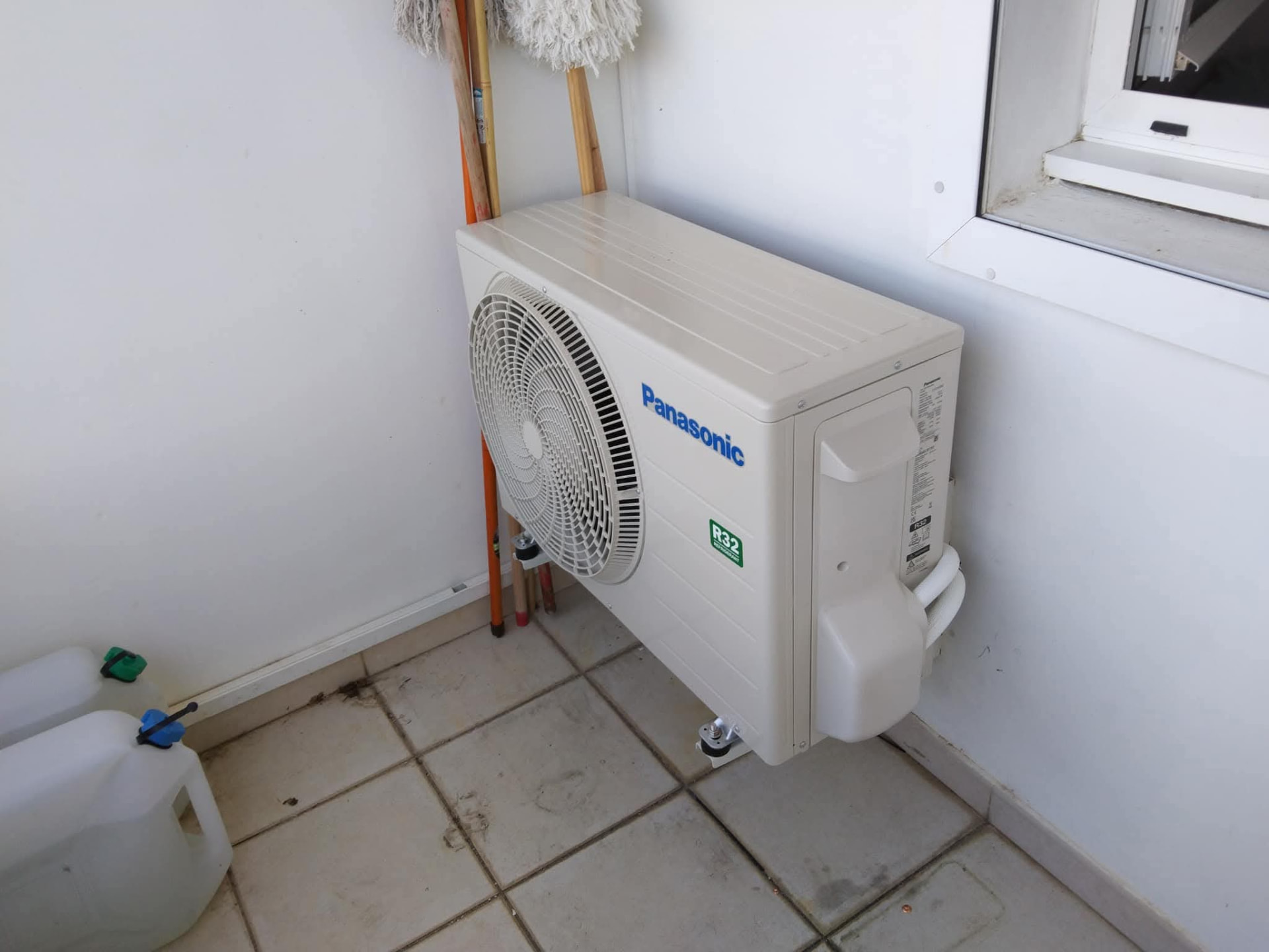 Remplacement 9K BTU Panasonic – Rivière Salée – climatisation Martinique Unité extérieure Panasonic fixée sur consoles murales sur une terrasse à Rivière-Salée, raccordements frigorifiques visibles et soignés – Rivière Salée, Martinique – LD CLIM 972